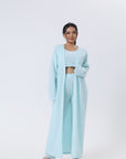 Cozy 3-piece pajama set for women, featuring a soft crop top, wide-leg pants, and a matching knee-length pullover in pastel colors.