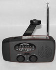 Solar hand crank radio with USB charging port, red in color. Features include a Midland Weather Alert Radio, hand crank radio flashlight, and solar charging capabilities, designed for emergency preparedness and outdoor use.