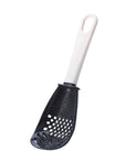 Close-up of a multifunctional slotted spoon grinding cooking spoon, showcasing its innovative design for mashing garlic, ginger, and potatoes, doubling as a stir-frying spatula and versatile kitchen gadget.