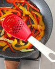 Close-up of a multifunctional slotted spoon grinding cooking spoon, showcasing its innovative design for mashing garlic, ginger, and potatoes, doubling as a stir-frying spatula and versatile kitchen gadget.