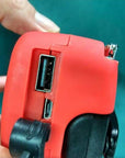 Solar hand crank radio with USB charging port, red in color. Features include a Midland Weather Alert Radio, hand crank radio flashlight, and solar charging capabilities, designed for emergency preparedness and outdoor use.