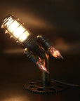 "Vintage steampunk rocket lamp with intricate detailing and a glowing flame night light. This unique rocket ship lamp adds retro-futuristic charm to any room, perfect for use as a steampunk desk lamp, or stylish lighting for your bar, store, or office. Featuring high-quality craftsmanship and an E26 bulb for bright illumination, this steampunk lighting fixture enhances any space with its vintage appeal.