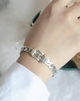 Elegant sterling silver belt bracelet with geometric design and platinum plating, featuring a unique belt buckle style.