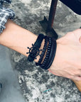 4Pcs/Set braided leather bracelets with wooden beads and rustic charms, including life tree and rudder designs, offering a vintage tribal-inspired look with braided patterns and durable leather for a stylish, ethnic accessory.
