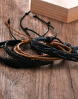 4Pcs/Set braided leather bracelets with wooden beads and rustic charms, including life tree and rudder designs, offering a vintage tribal-inspired look with braided patterns and durable leather for a stylish, ethnic accessory.