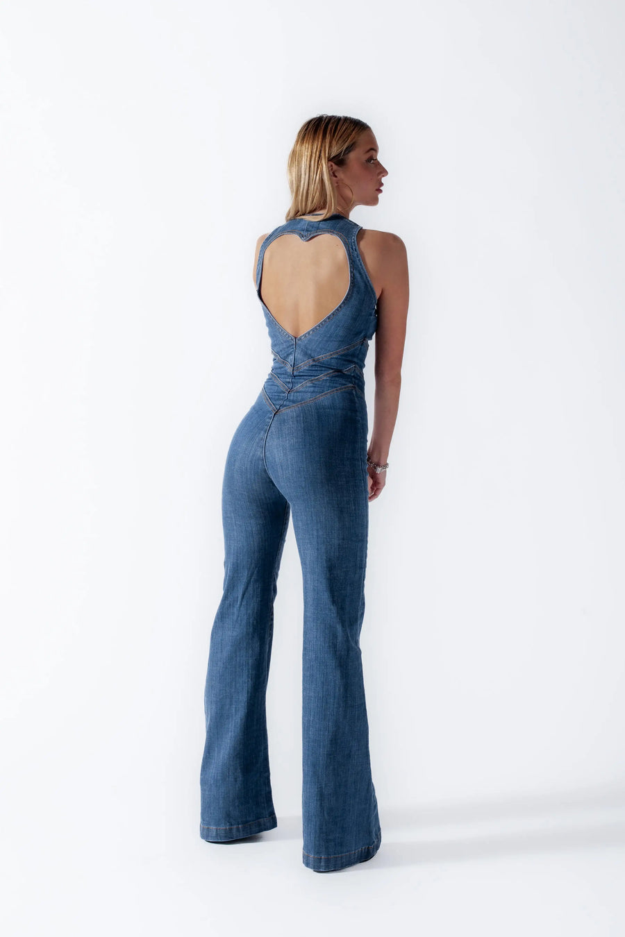 Heart cutout jumpsuit Backless jumpsuit Romantic jumpsuit Figure-flattering jumpsuit Special occasion attire Elegant jumpsuit Eye-catching outfit Fashion-forward jumpsuit Playful back detail Head-turning style