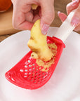 Close-up of a multifunctional slotted spoon grinding cooking spoon, showcasing its innovative design for mashing garlic, ginger, and potatoes, doubling as a stir-frying spatula and versatile kitchen gadget.