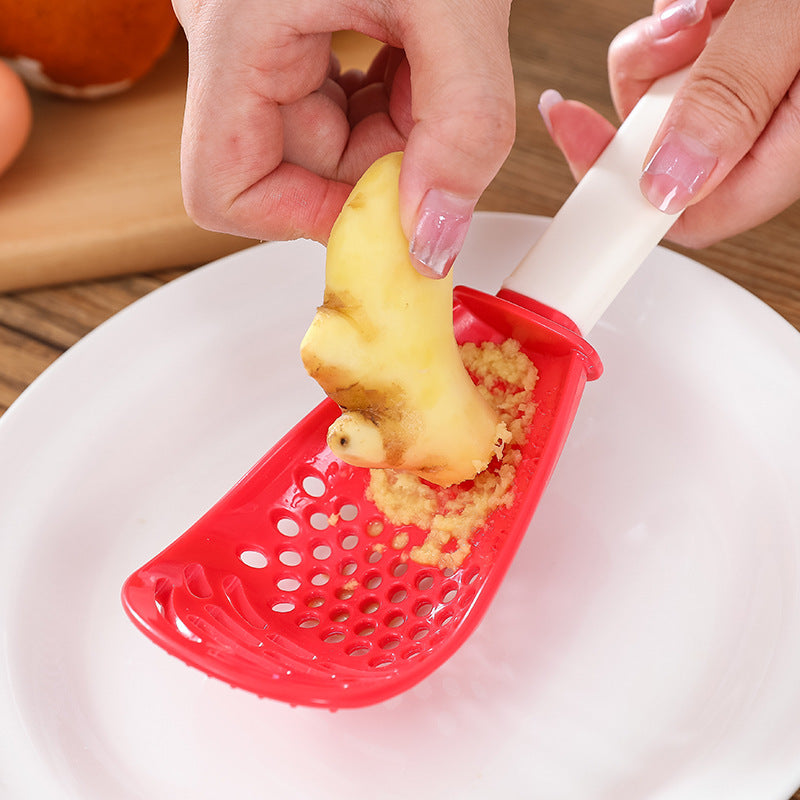 Close-up of a multifunctional slotted spoon grinding cooking spoon, showcasing its innovative design for mashing garlic, ginger, and potatoes, doubling as a stir-frying spatula and versatile kitchen gadget.