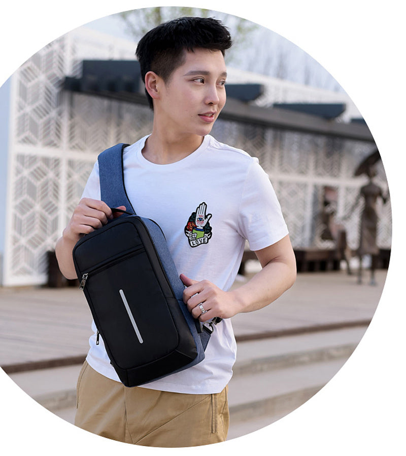 Anti-theft crossbody sling bag made from durable polyester, featuring a USB charging port, computer pocket, and soft surface. Ideal for secure storage and on-the-go charging, with a stylish, casual design and car suture detail.