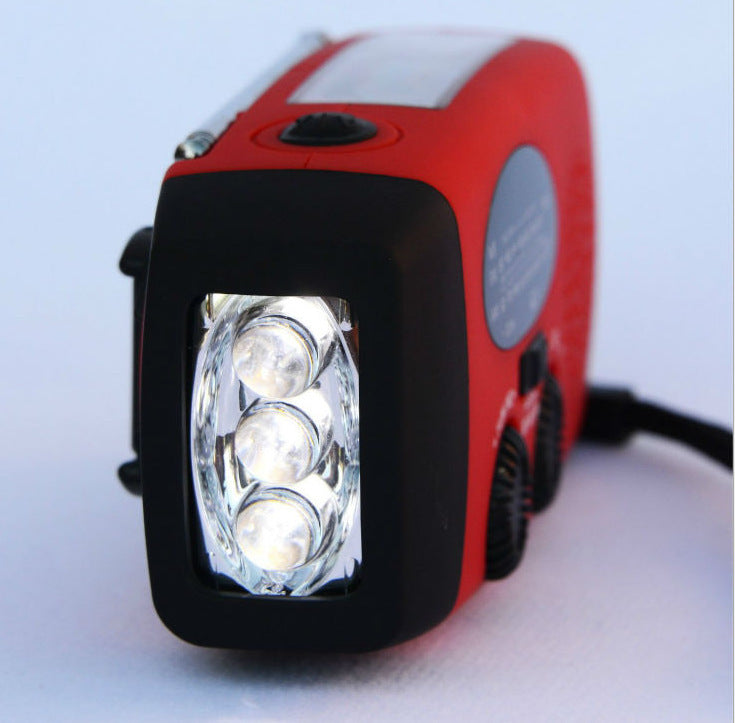 Solar hand crank radio with USB charging port, red in color. Features include a Midland Weather Alert Radio, hand crank radio flashlight, and solar charging capabilities, designed for emergency preparedness and outdoor use.