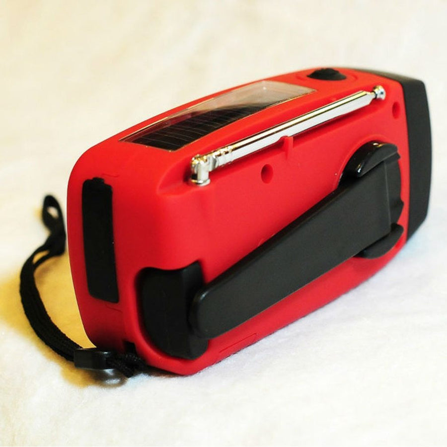 Solar hand crank radio with USB charging port, red in color. Features include a Midland Weather Alert Radio, hand crank radio flashlight, and solar charging capabilities, designed for emergency preparedness and outdoor use.
