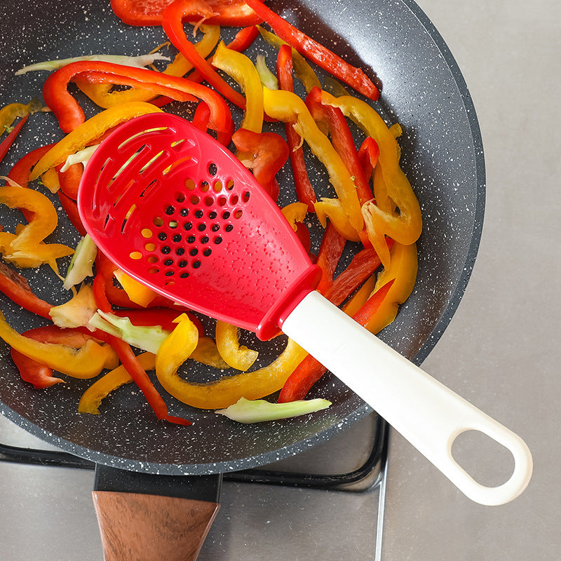 Close-up of a multifunctional slotted spoon grinding cooking spoon, showcasing its innovative design for mashing garlic, ginger, and potatoes, doubling as a stir-frying spatula and versatile kitchen gadget.